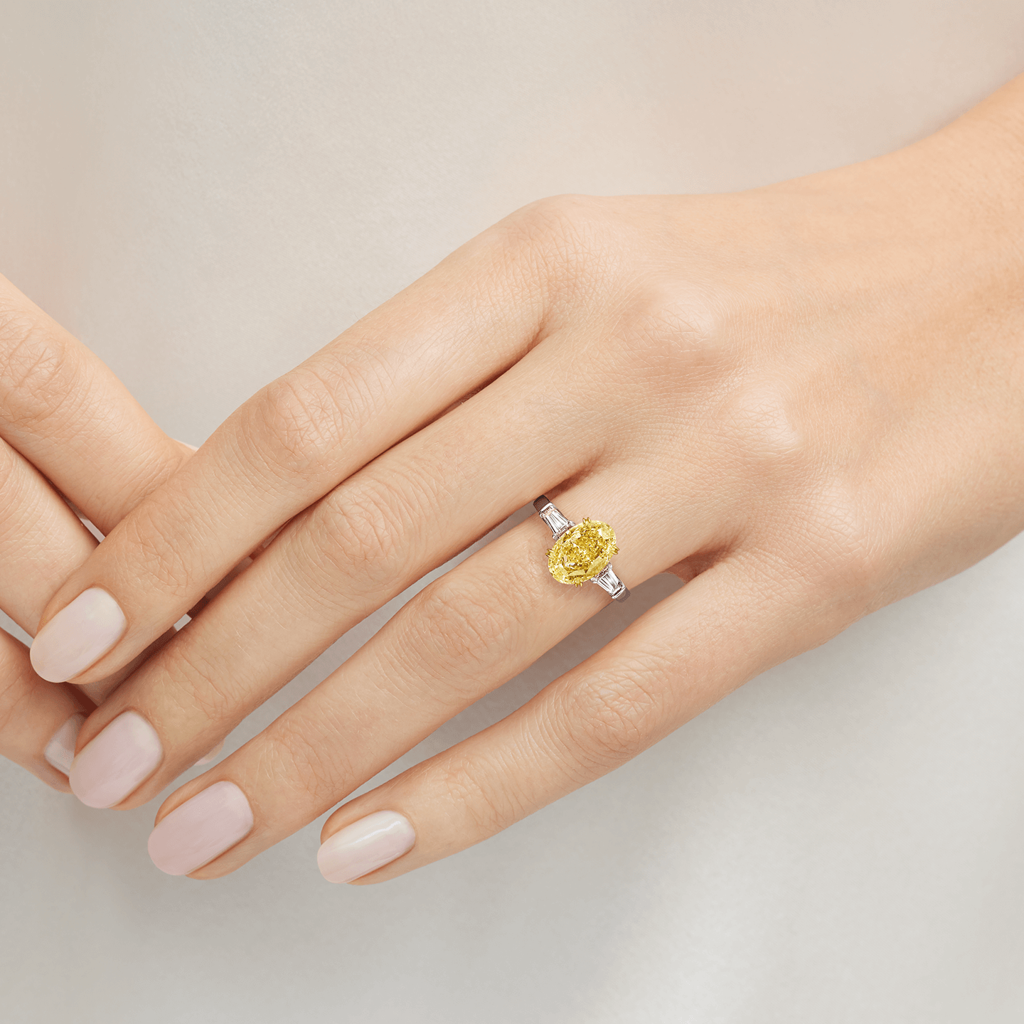 Bague Classic Winston en diamant jaune taille ovale présentée sur un modèle 
